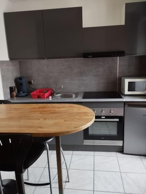 - une cuisine avec une table en bois et un évier dans l'établissement Appartement Brest Saint Martin, à Brest