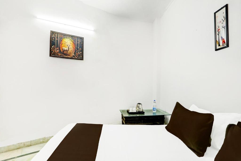 Vikram singh في نيودلهي: غرفة نوم بيضاء مع سرير وطاولة