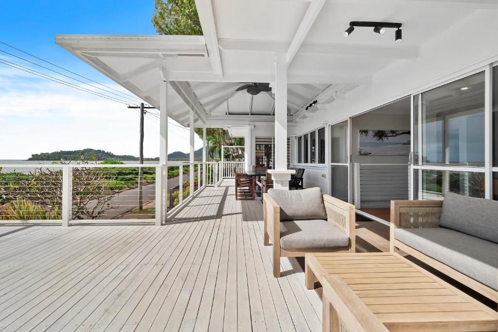 an open deck with chairs and tables on a house at Seaside Rest at Clifton Beach in Clifton Beach