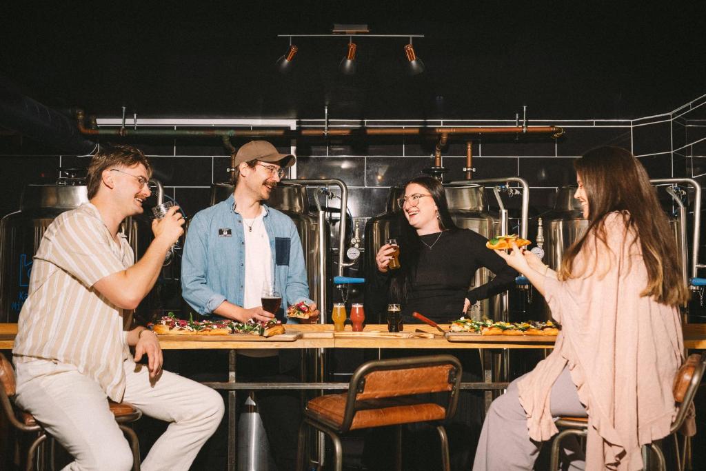 Un gruppo di persone seduti intorno a un tavolo che mangiano cibo di The Brewery Hotel a Karlskrona