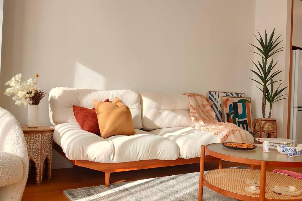 a living room with a white couch with pillows on it at Brand-new Modern Princess in One Tree Hill in Auckland