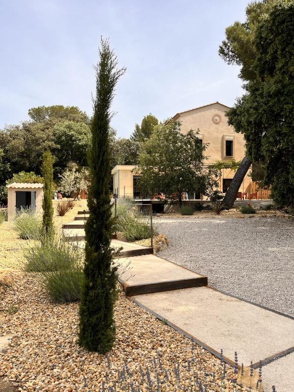 un arbre en face d'un bâtiment avec une aire de jeux dans l'établissement Villa du Tallagard, à Salon-de-Provence