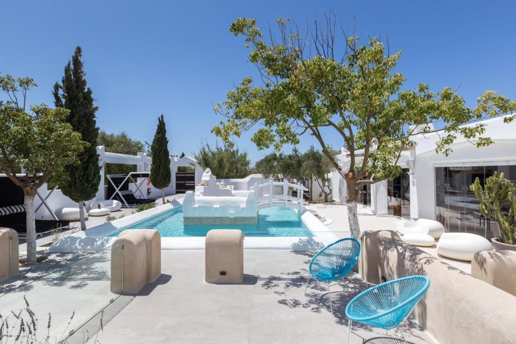 - une piscine avec des chaises et une maison dans l'établissement Kallos Villas & Suites, à Naxos Chora