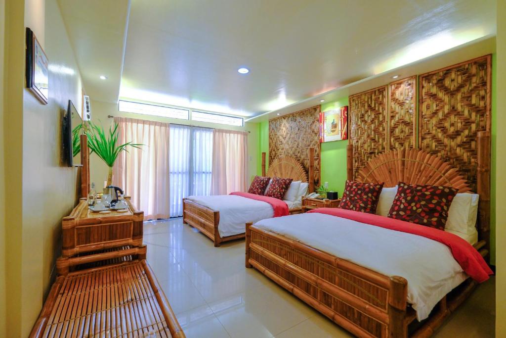 Habitación de hotel con 2 camas y sofá en Malapascua Exotic Island Dive Resort en Daanbantayan