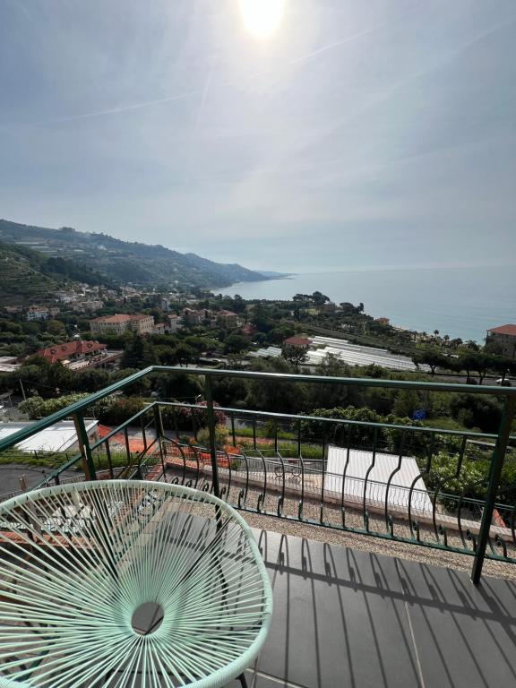 a chair on a balcony with a view of the ocean at Agriturismo Un Mare di Fiori in Ventimiglia
