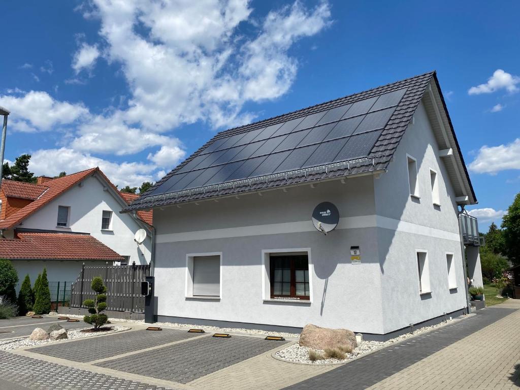 uma casa com painéis solares no telhado em Ferienhaus _GlueckSEEligkeit_ em Großkoschen