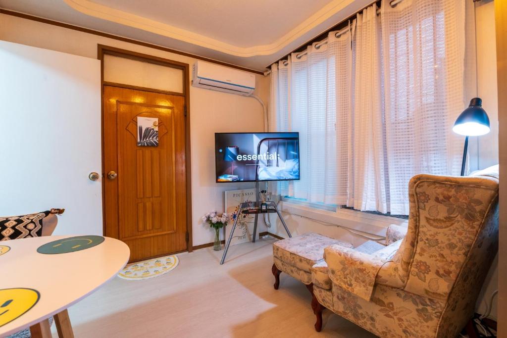 ein Wohnzimmer mit einem Stuhl und einem TV in der Unterkunft Stay CarpeDiem Hannam in Seoul