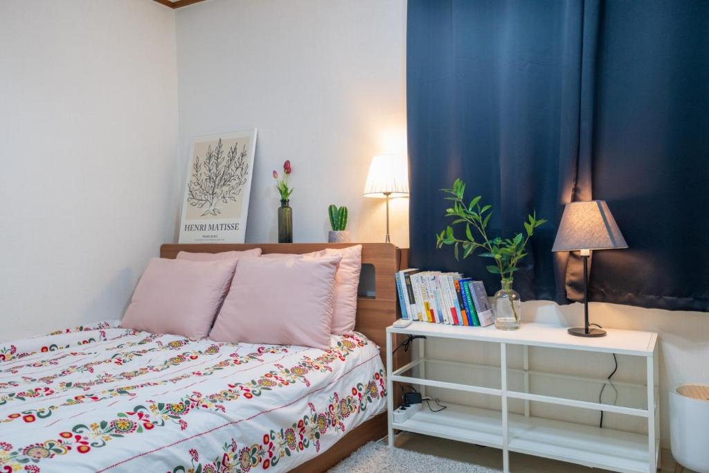 ein Schlafzimmer mit einem Bett und einem Tisch mit Büchern in der Unterkunft Stay CarpeDiem Hannam in Seoul