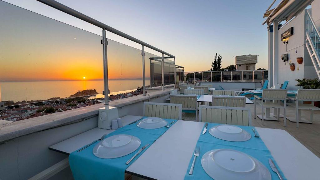 a table on a balcony with a view of the ocean at La Bella Suit Otel in Kuşadası