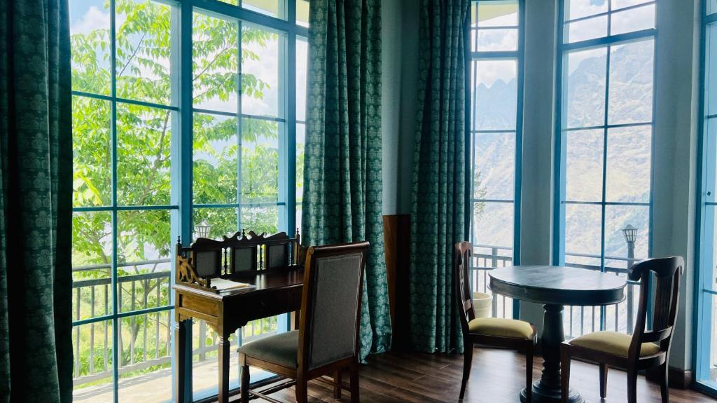a desk in a room with a large window at Faraway Cottages, Auli in Joshīmath