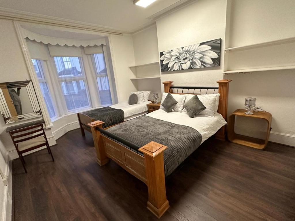 a bedroom with two beds and a table in it at PRIVATE ROOM In TOWN CENTRE FREE PARKING WI FI AND PATIO WITH AA STAY LTD in Buckinghamshire