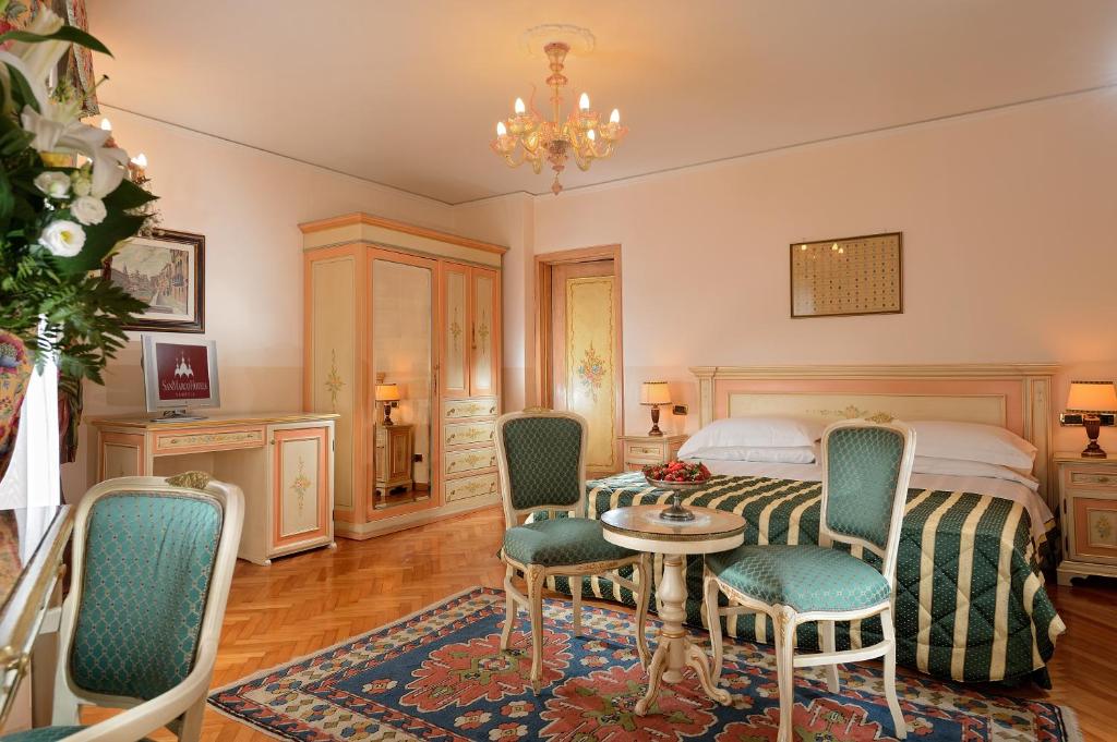 a bedroom with a bed and a table and chairs at Albergo Cavalletto &amp; Doge Orseolo in Venice