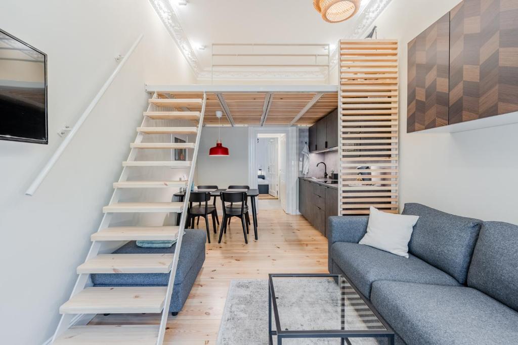 ein Wohnzimmer mit einer Leiter und einer blauen Couch in der Unterkunft Urban Smart Kreuzberg in Berlin