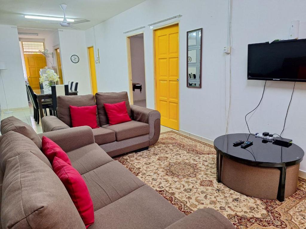 sala de estar con 2 sofás y TV en IBRAHIM’S HOMESTAY en Kuala Kerai