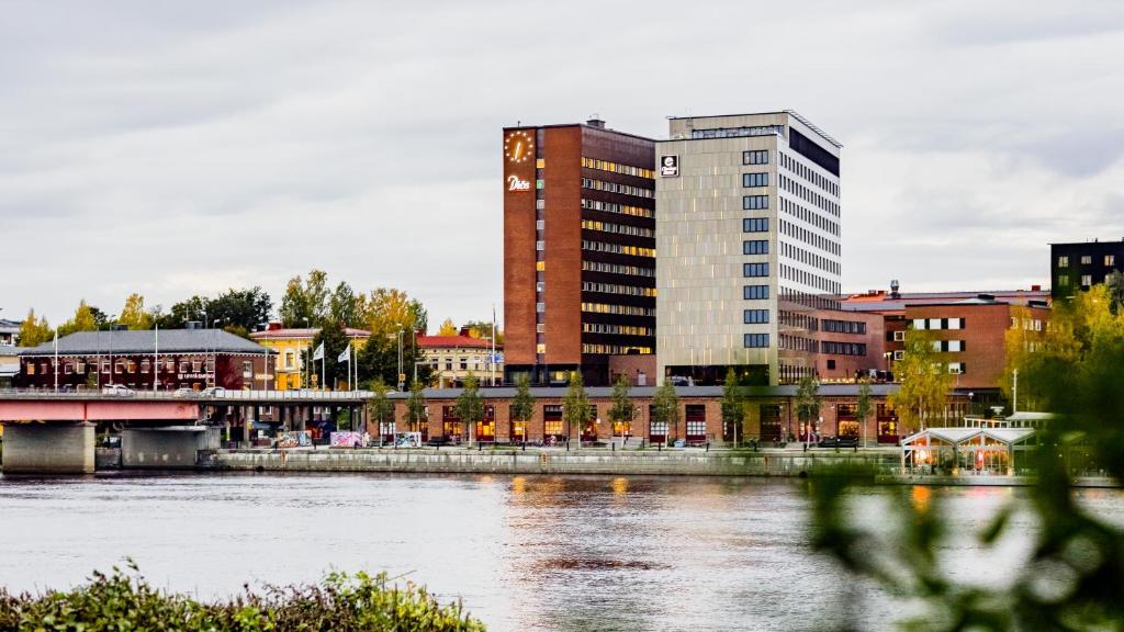 a city with a tall building next to a river at Clarion Hotel Umeå in Umeå