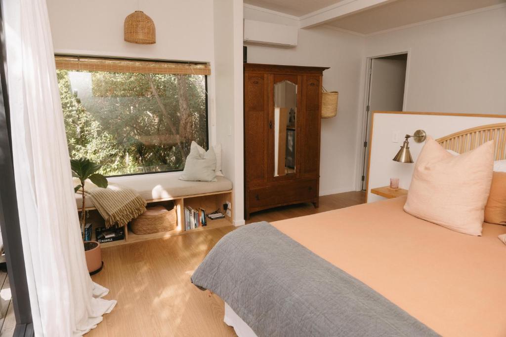 Schlafzimmer mit einem Bett und einem Fenster in der Unterkunft Treehouse Hideaway in Opua