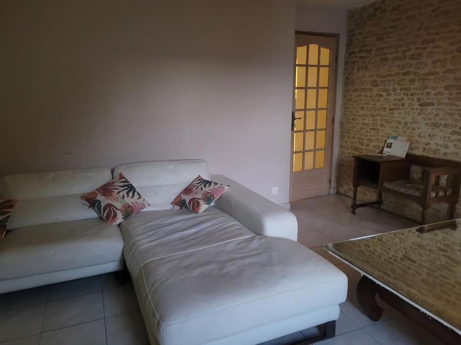 un salon avec un canapé blanc et une table dans l'établissement Appartement en duplex spacieux, à Colleville-Montgomery