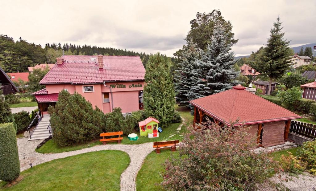 una casa con techo rojo y patio en Willa Asia, en Szklarska Poręba