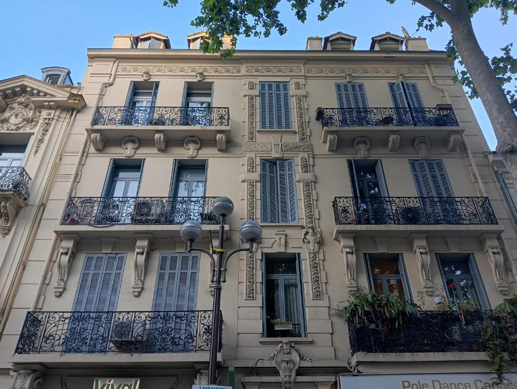 un grand bâtiment blanc avec balcon et lumière de rue dans l'établissement Maison Carnot, à Cannes