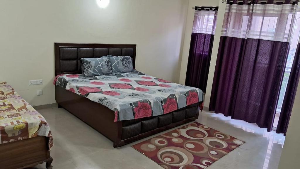 Un dormitorio con una cama y cortinas y una alfombra. en Vrinda Homestay, en Vrindāvan
