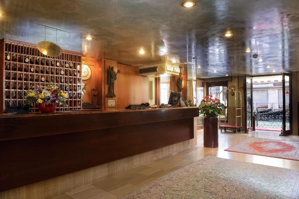 a lobby with a bar with flowers on the wall at Albergo Cavalletto &amp; Doge Orseolo in Venice