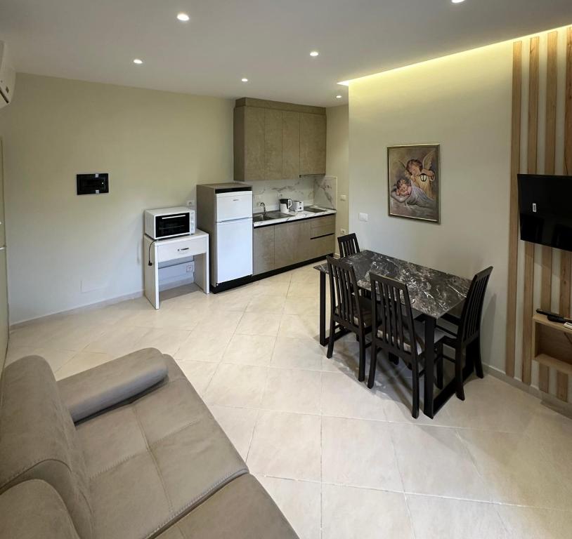 a living room with a table and chairs and a kitchen at Neti Apartments in Vlorë