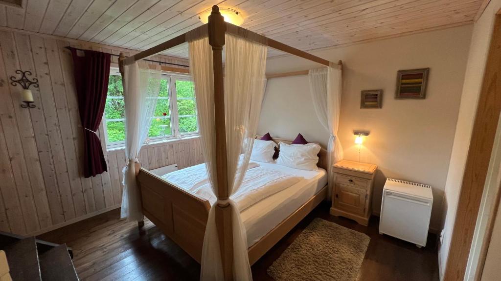 a bedroom with a canopy bed and a window at Dalen Bed & Breakfast in Dalen