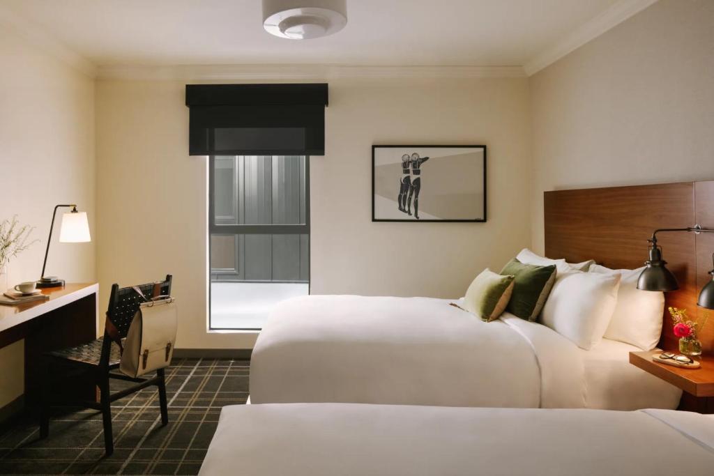 ein Hotelzimmer mit zwei Betten und einem Schreibtisch in der Unterkunft FOUND Hotel, Santa Monica in Los Angeles