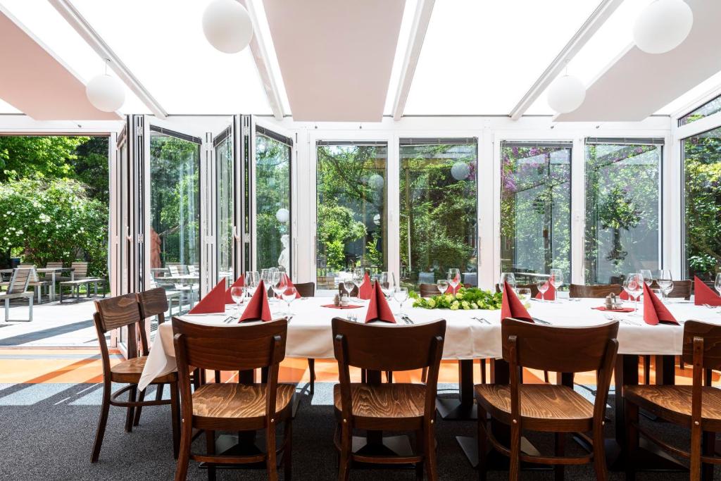 a dining room with a table with red napkins at Hotel Grenzfall in Berlin