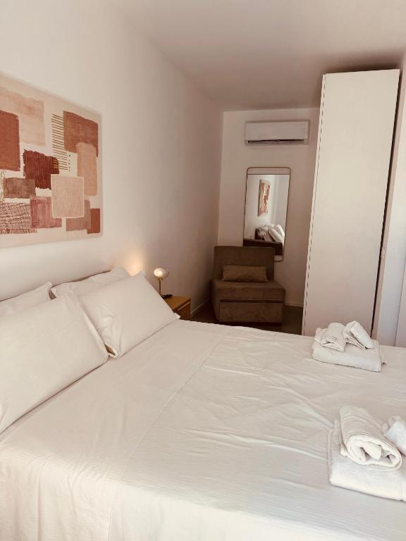 巴里Marisabella Suite 9的卧室里有一张白色的床，床上放着毛巾