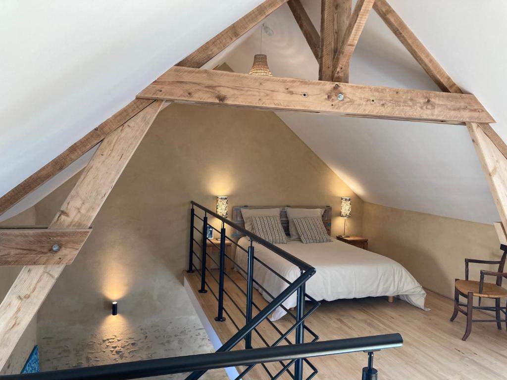 ein Loft-Schlafzimmer mit einem Bett und einer Treppe in der Unterkunft Le 6 