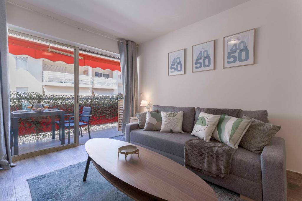 un salon avec un canapé et une table dans l'établissement Amandier du Moure Rouge, à Cannes