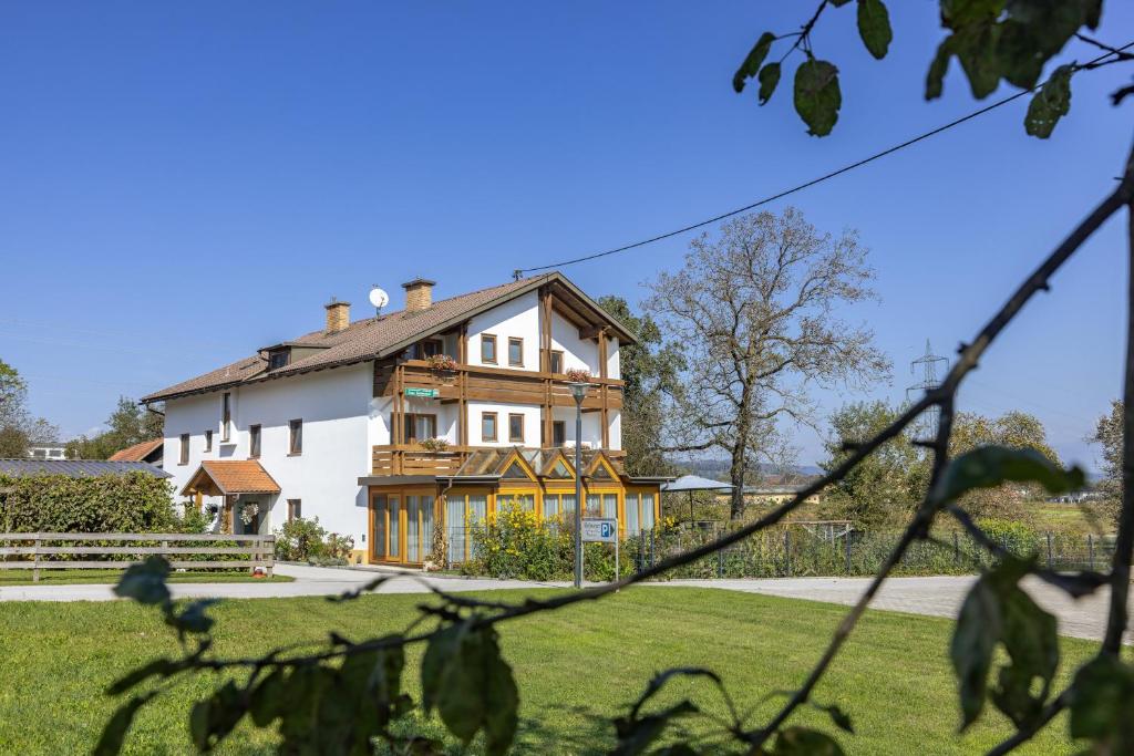 una gran casa blanca en un campo de hierba en Bauernhof Pension Hofmayer, en Sankt Kanzian