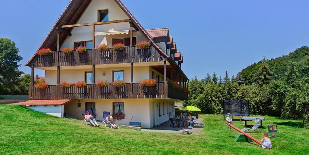 a building with people sitting in front of it at Ferienwohnung Bickel - Am großen Brombachsee in Spalt