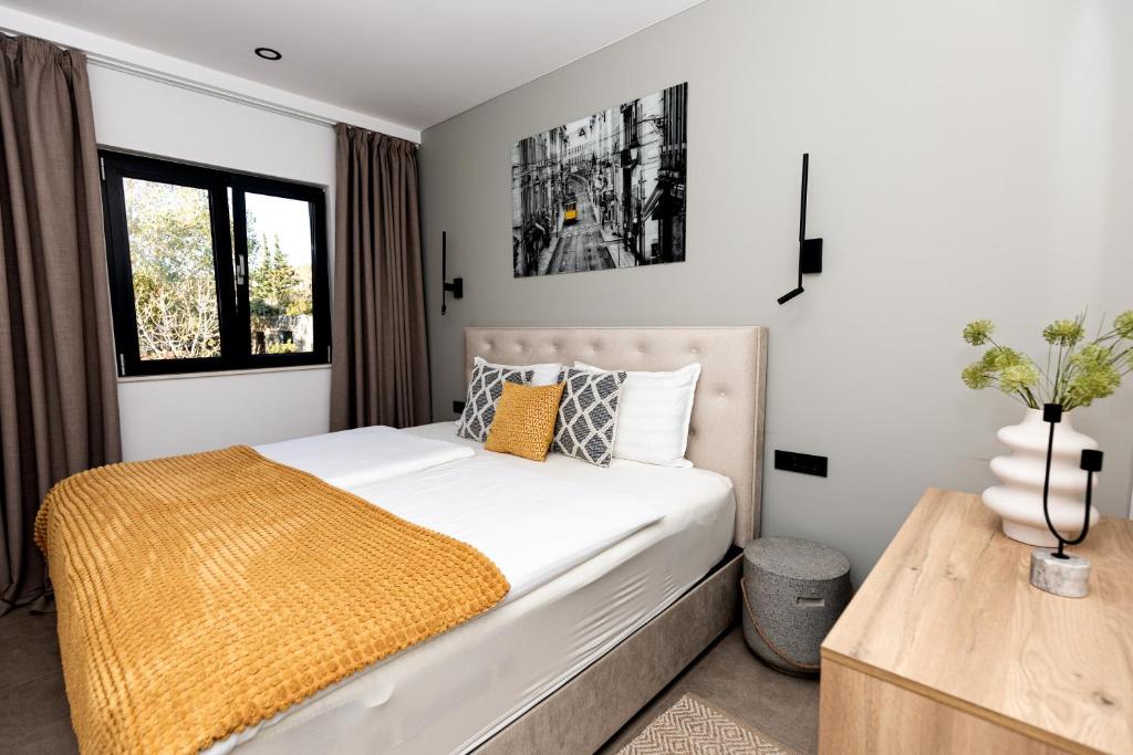 - une chambre avec un lit blanc et une couverture jaune dans l'établissement Villa Barovic - Premium apartment, à Mlini