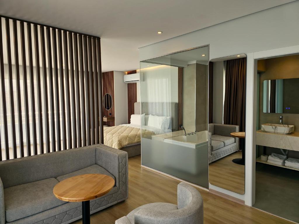 ein Hotelzimmer mit einem Sofa und einem Bett in der Unterkunft Hotel Enkelana in Pogradec