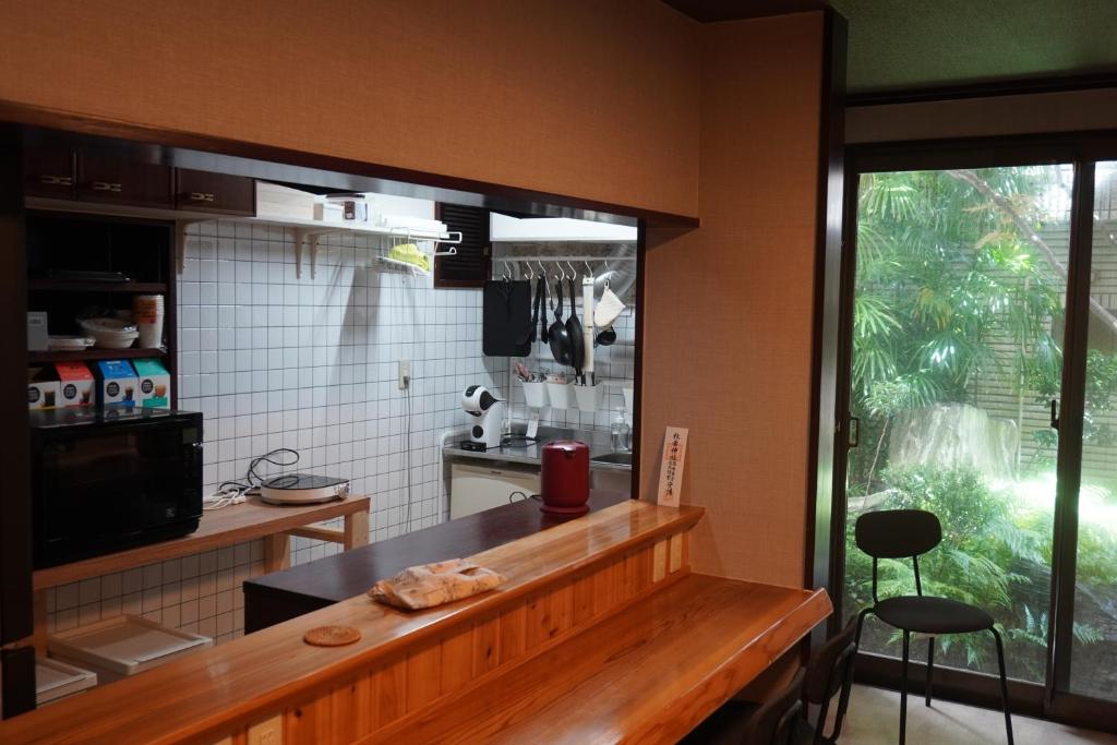 a kitchen with a counter and some stools in it at Guest House BONITO in Kochi