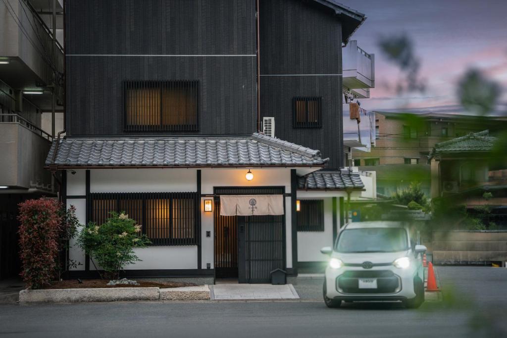 a car parked in front of a building with its lights on at 谷町君・星屋旅館・晴博・京都嵐山 in Shimo saga