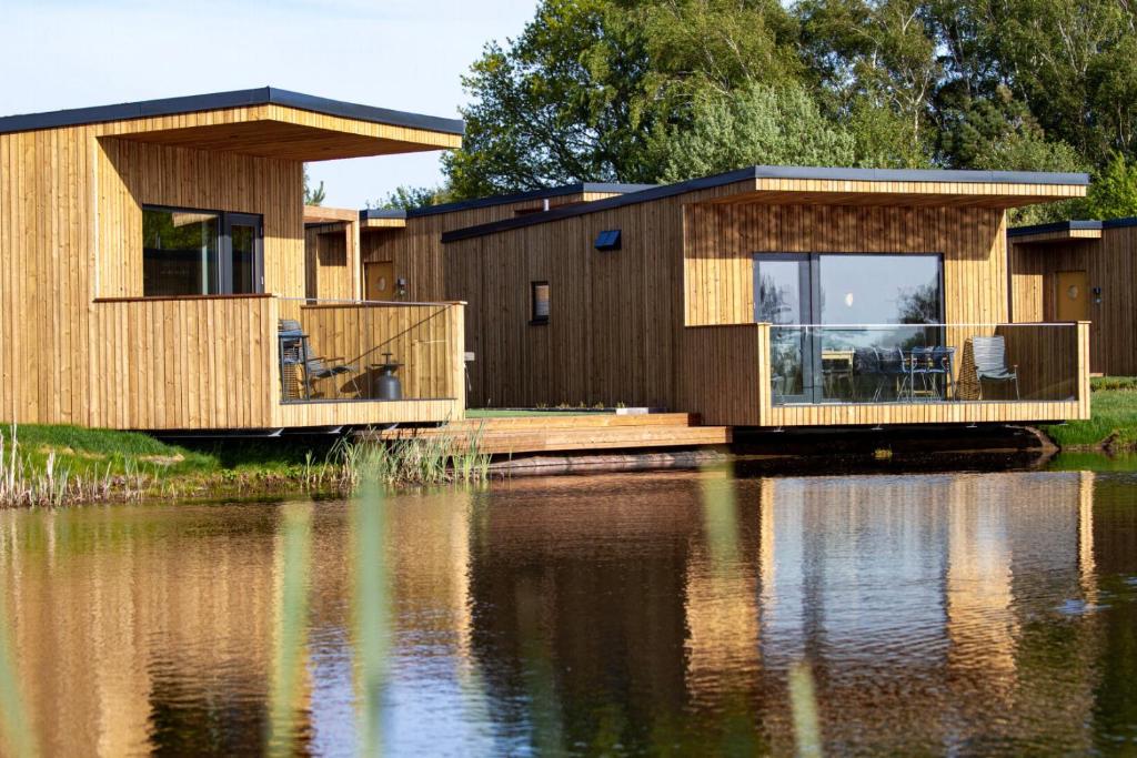 a house on a dock next to a body of water at Halmstad Golfarena Hotell & Lägenheter in Halmstad