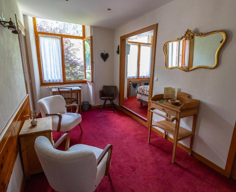 - un salon avec un miroir, des chaises et un miroir dans l'établissement Chateau De La Muzelle, à Vénosc