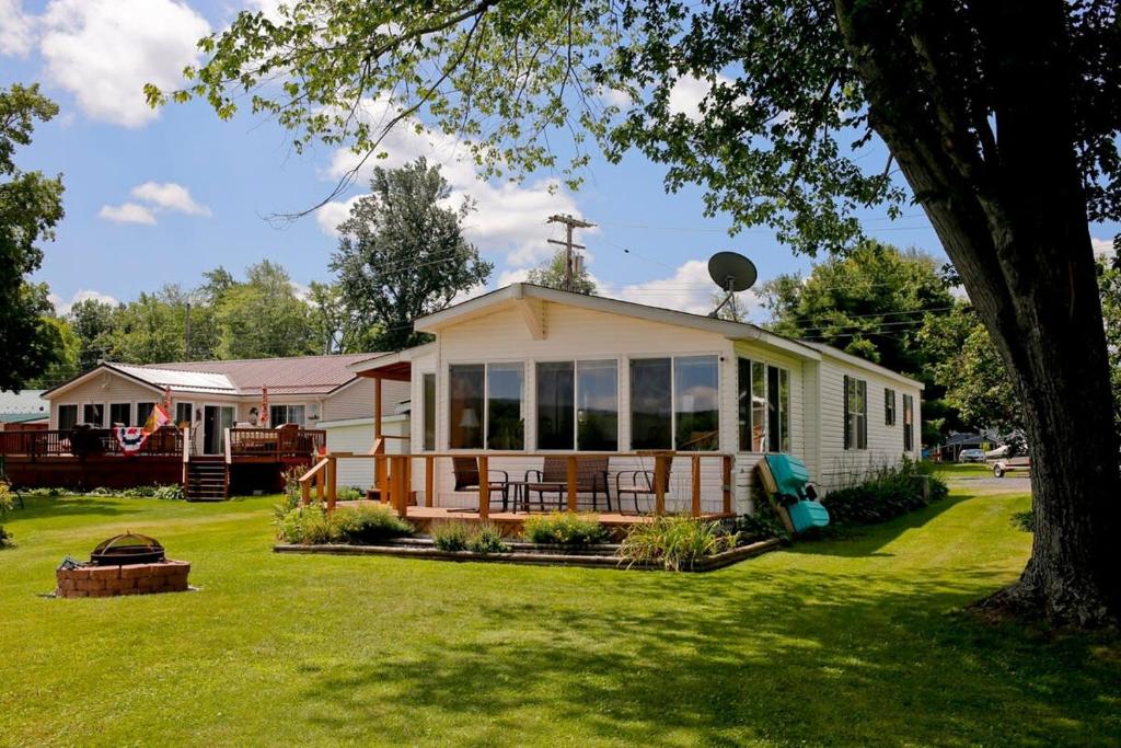 a small white house with a large porch at Weller Island Bliss in Hammondsport