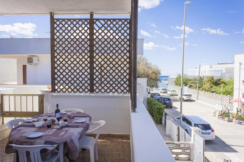 una mesa en un balcón con vistas a la calle en Torre Lapillo Apartment Sea View - Happy Rentals, en Porto Cesareo