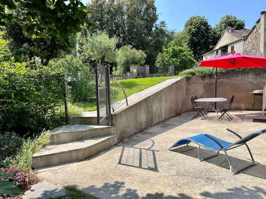une terrasse avec une table, une chaise et un parasol dans l'établissement Location entre mer, montagne et rivières, à Casanova