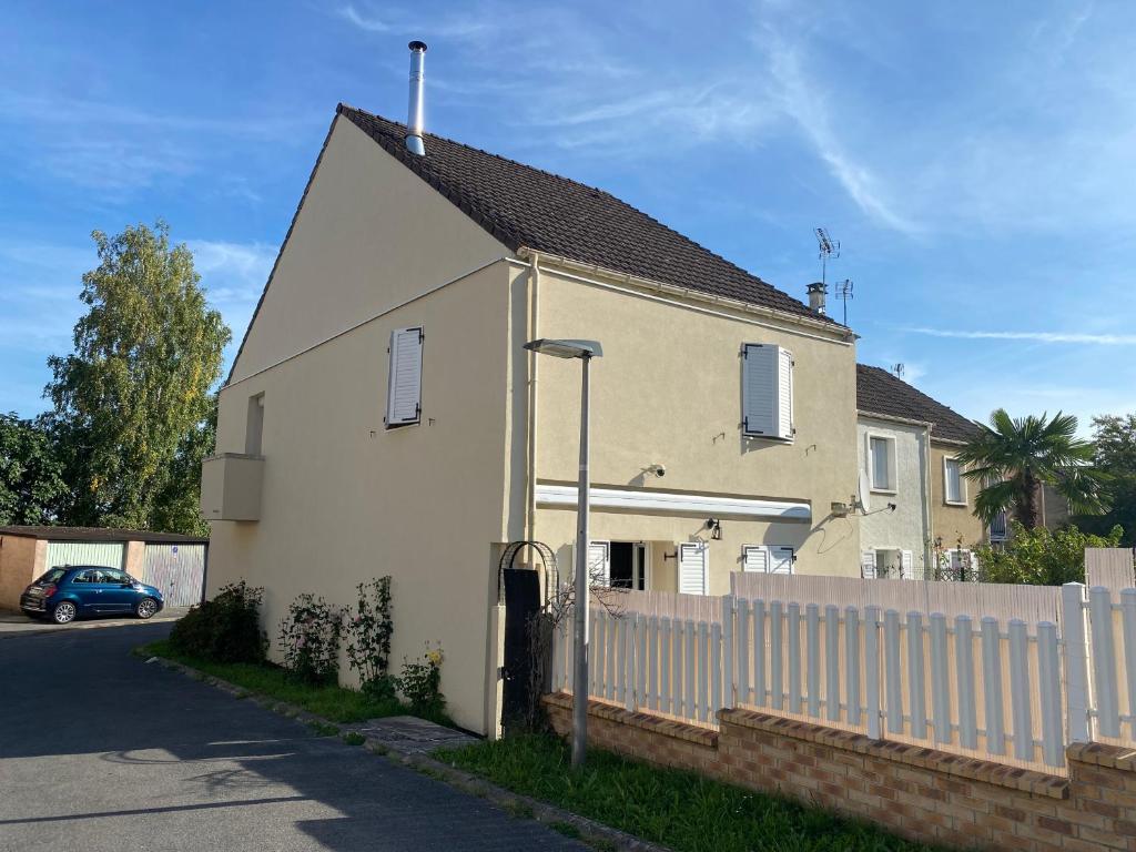 une maison blanche avec une clôture à côté d'une rue dans l'établissement Chez Manu Meublé de tourisme 2 étoiles pour 6 personnes - 3 chambres, à Villeparisis