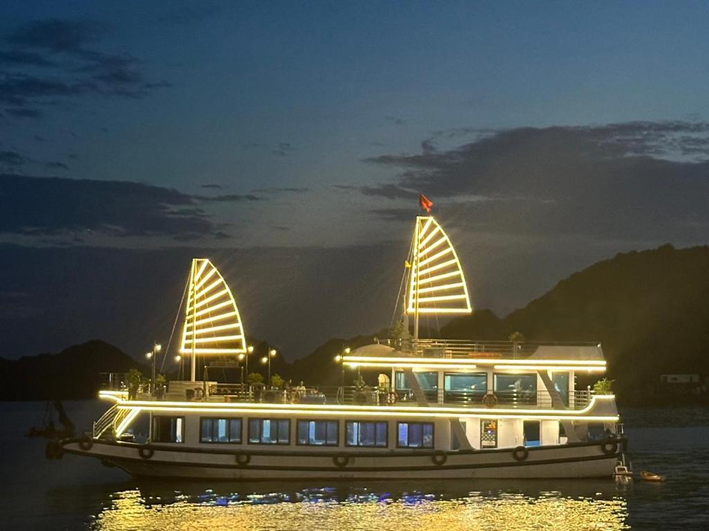 a large boat in the water at night at GOLDEN LAND HOTEL in Cat Ba