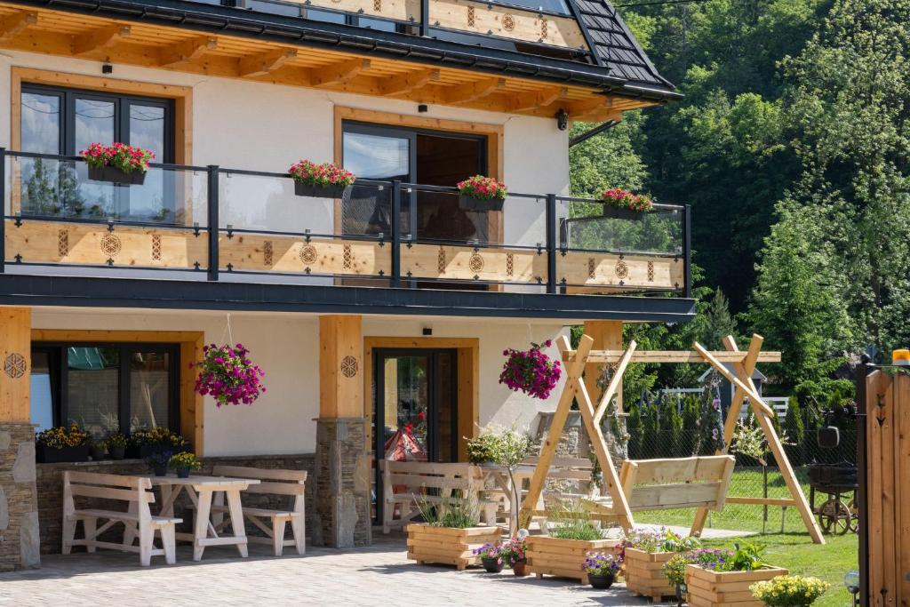 een huis met een balkon en een tafel bij Kominkowy Chill - prywatne zewnętrzne jacuzzi w wybranych apartamentach in Biały Dunajec