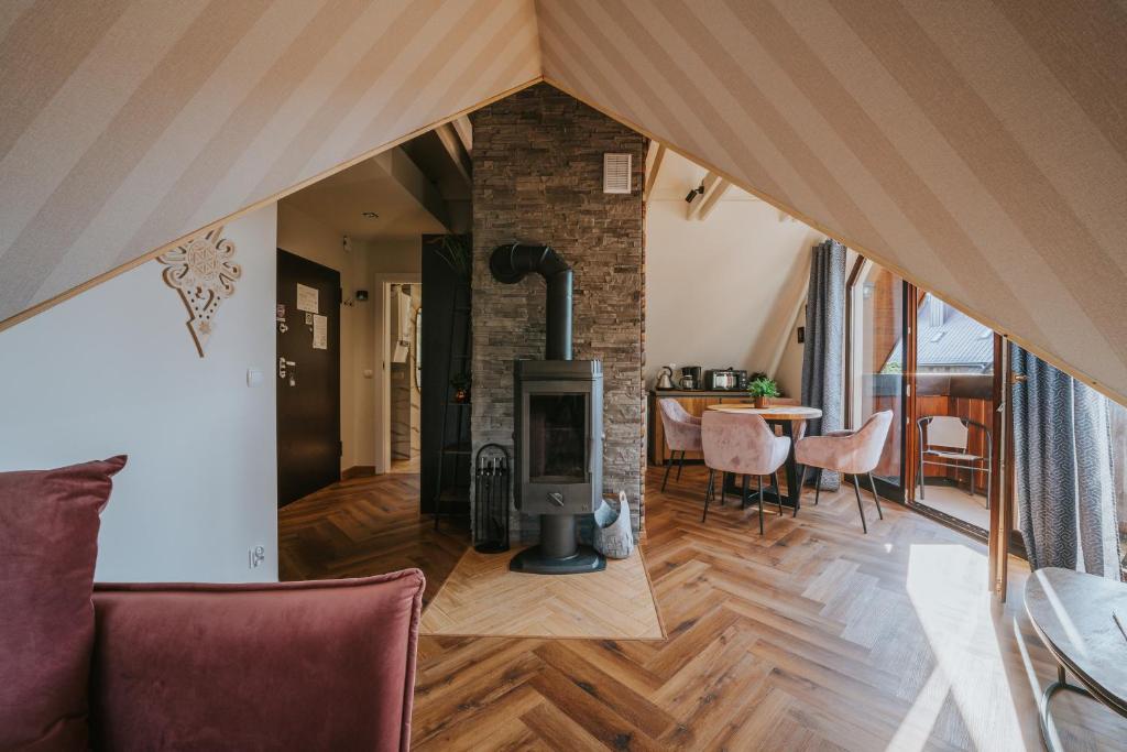 a living room with a fireplace in a house at Visitzakopane - Supernova apartment in Zakopane