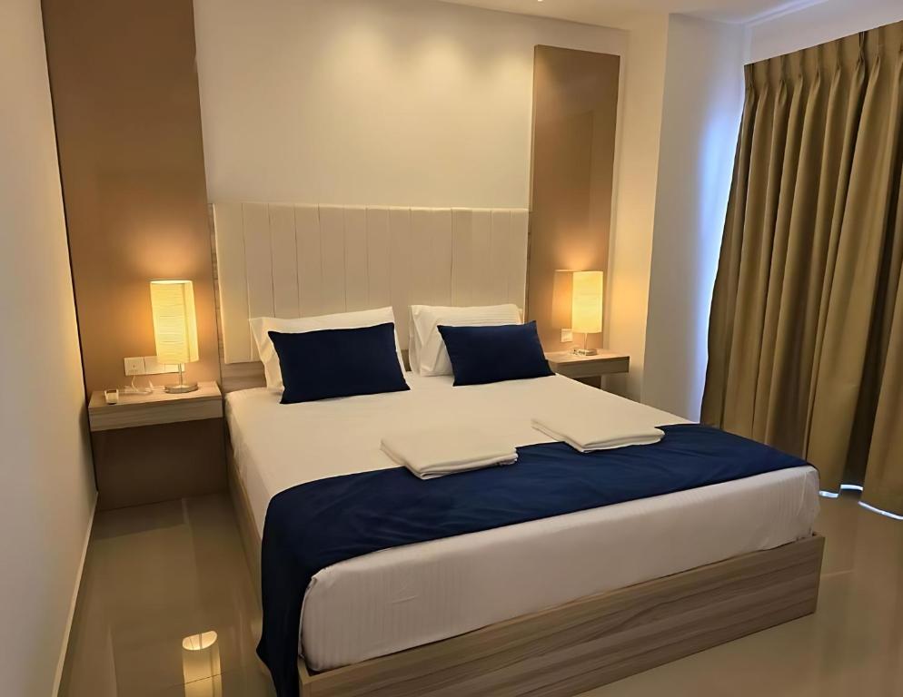 una camera da letto con un grande letto con cuscini blu di Negombo Bliss on the Beach Luxury Studios by Serendib Vacation a Negombo