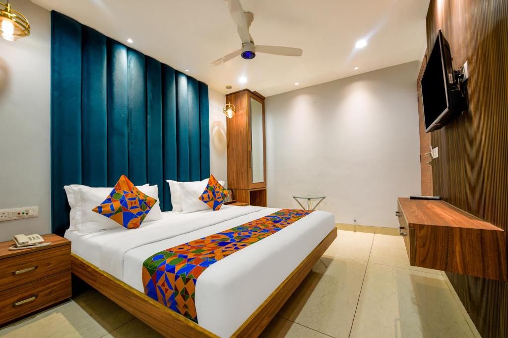 um quarto com uma cama grande e uma parede azul em FabHotel Rolt em Ludhiana