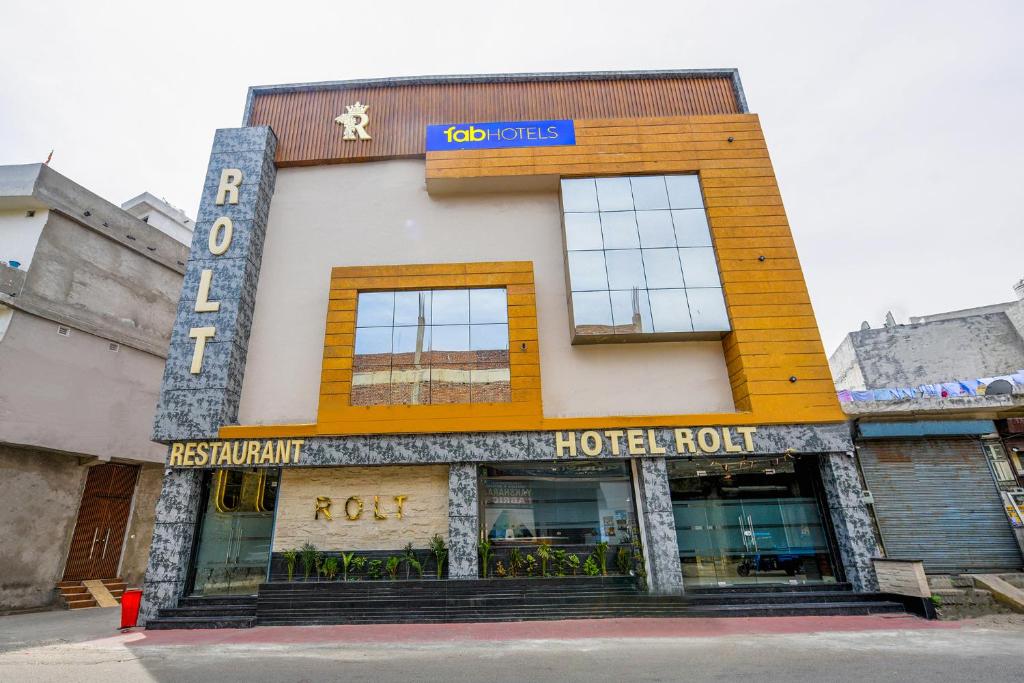 a hotel front of a building with a hotel room at FabHotel Rolt in Ludhiana